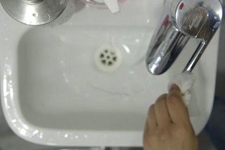 image of turning off the tap using a disposable towel