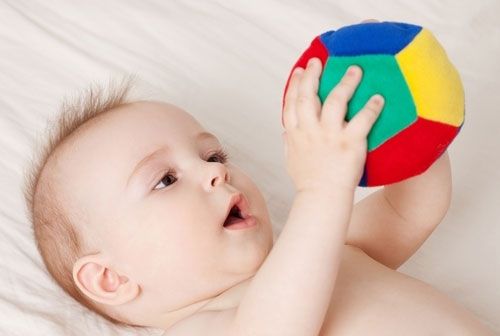 Младенец играет с мячом