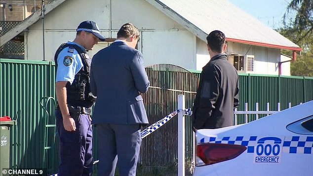 Police gather outside the home the night after the alleged 