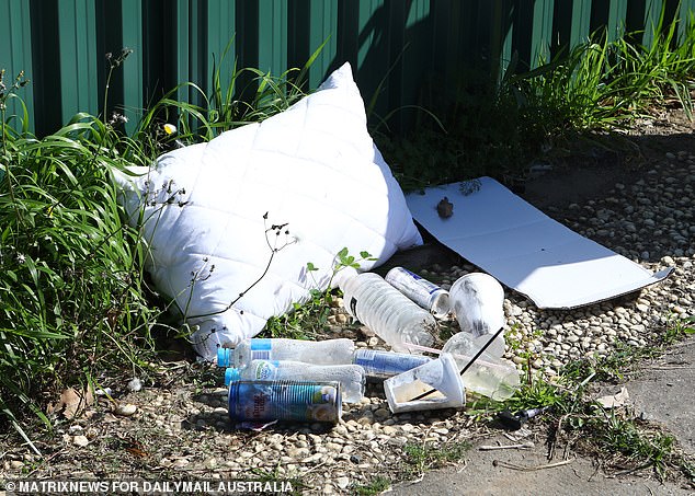 The front garden: Piles of water bottles, Red Bull and coconut drink are heaped in the front yard along with a mattress and an old pillow
