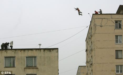 Sport: A parkour practitioner jumps from an 18-meters high roof to 14-meters high roof across a 7-meters wide gap in St. Petersburg, Russia