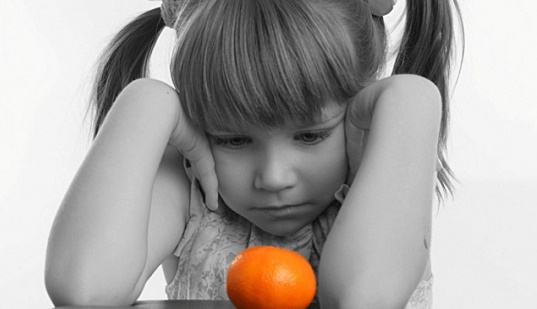 девочка не может съесть апельсин