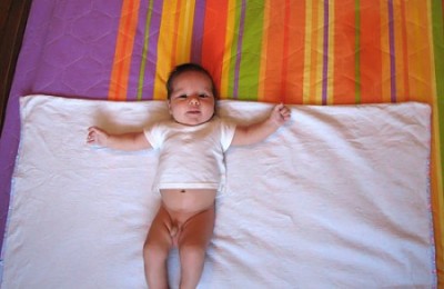 Кладем малыша на пеленку так, чтобы его шея лежала на верхней кромке пеленки